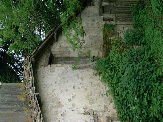 Ancien logis, façade latérale droite avec escalier en pierre donnant accès au comble.