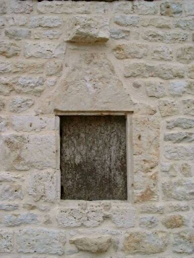 Logis, façade antérieure, porte d'entrée, détail de la baie à gauche de la porte d'entrée.