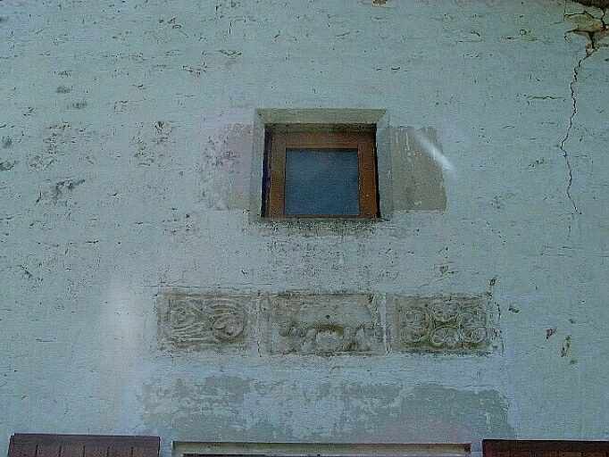 Logis, élévation antérieure, détail de la baie chanfreinée de droite du comble à surcroît à encadrement chanfreiné et du décor sculpté au-dessous.