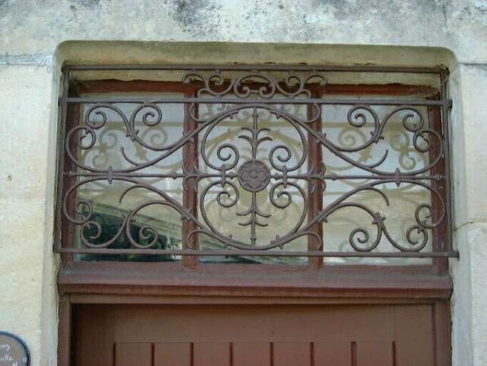 Logis, élévation postérieure, porte d'entrée, détail de la grille de fer forgé protégeant l'imposte vitrée.