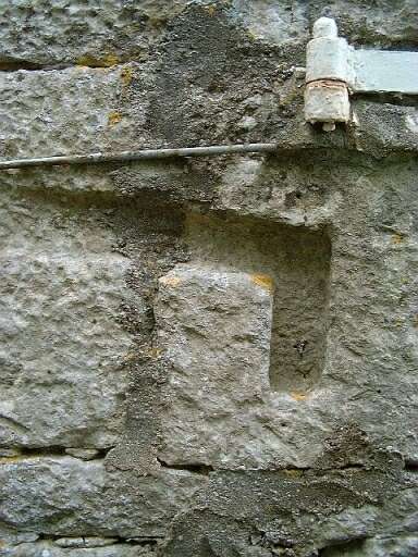 Orangerie accolée à un hangar, élévation sud, montant du portail de gauche, pierre de réemploi, vue prise du sud.