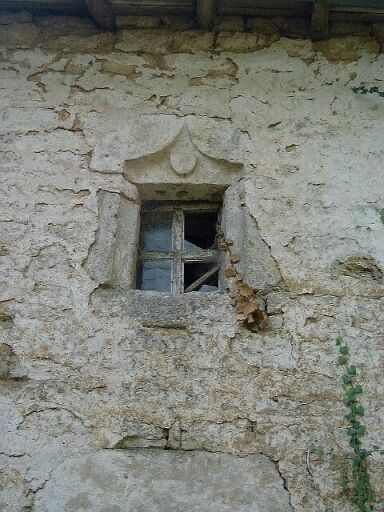 Logis, élévation antérieure nord, travée centrale, détail de la baie de l'étage dont le linteau est orné d'un blason muet dans une accolade.