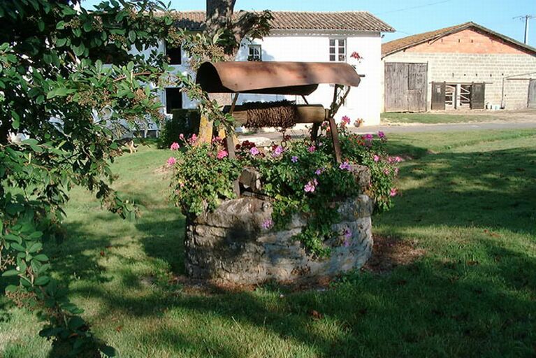 Le puits, au fond, la façade du logis et à droite l'ancienne grange-étable reconstruite, vue prise du sud-sud-est.