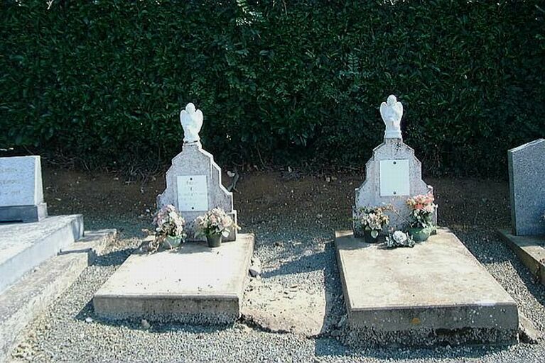 Tombes jumelles dont les stèles sont sommées d'un petit angelot de fabrication en série.