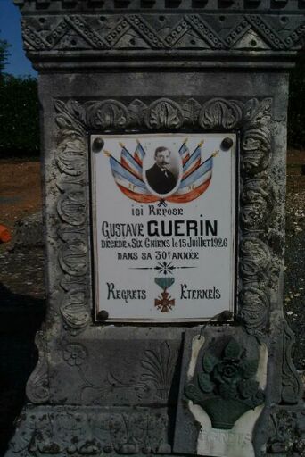 Le socle, détail de la plaque commémorative en porcelaine ornée d'une photo sur fond de drapeaux nationaux et de la croix de guerre (1926).