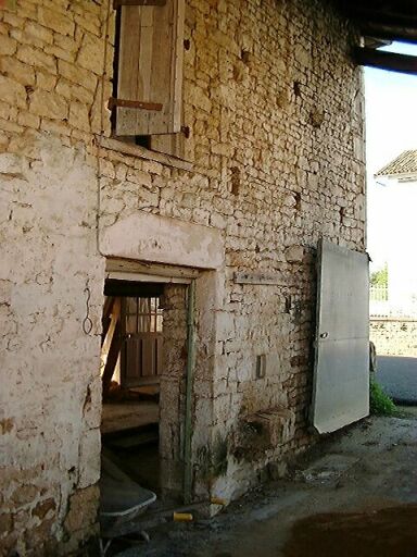 Logis, élévation latérale gauche sous le hangar, à droite des portes d'entrée du cellier et de décharge on remarque le chaînage du mur de refend intérieur, vue prise du nord-est.