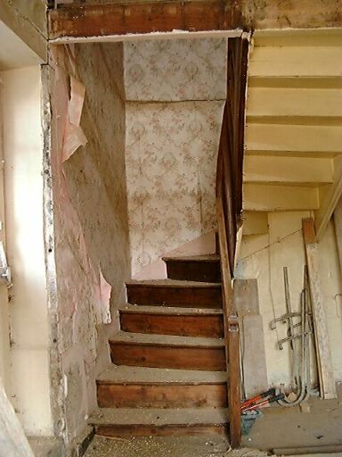 Logis, intérieur, vue de l'escalier tournant en bois situé dans l'angle nord-ouest du logis.