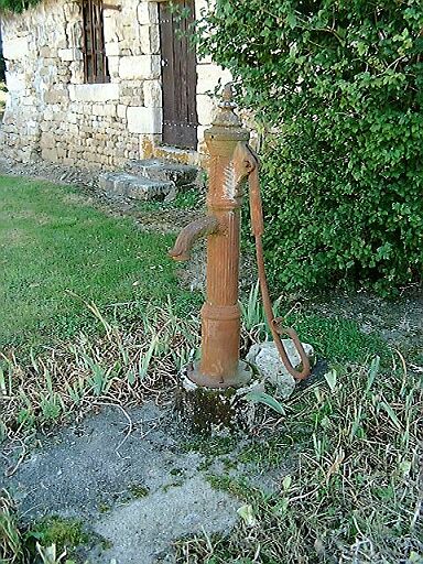 Pompe en fonte devant l'ancien logis.