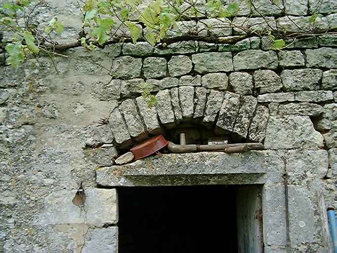 Bâtiment construit contre l'ancienne chapelle, élévation est, partie droite, porte partiellement chanfreinée avec un arc de décharge, détail.