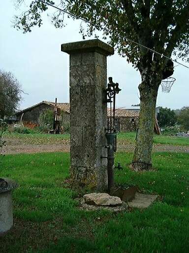 Puits, édicule avec corps de pompe en cuivre et balancier en fonte.