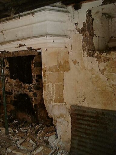 Logis principal, intérieur, rez-de-chaussée, cheminée, vue de trois-quarts.