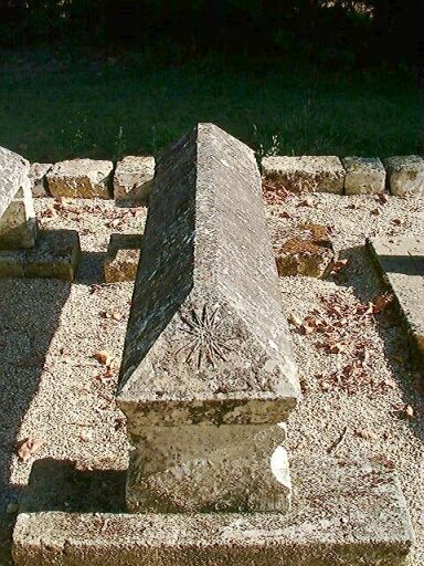 Cimetière privé familial, détail d'un tombeau en bâtière orné d'un soleil rayonnant.