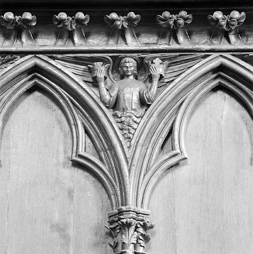 Dorsal des stalles disposées à gauche dans le choeur, détail de l'écoinçon placé entre les stalles 12 et 13 : ange tenant des couronnes.