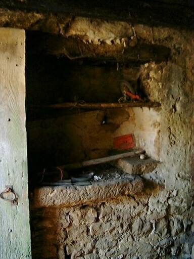Ancien logis, intérieur, pierre d'évier installée à gauche de la porte d'entrée, dans le mur de refend avec une dépendance à gauche.