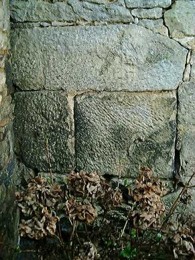 Ancien logis déclassé en dépendance agricole, élévation antérieure sud-est, angle gauche, vestige de la pierre d'évier et de la mise en oeuvre des pierres de contrepoids.