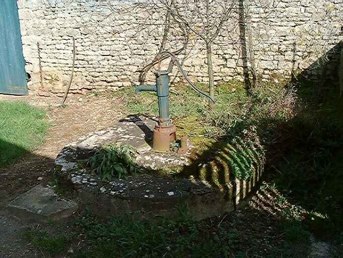 Puits et pompe à l'entrée de la cour du logis, à droite.