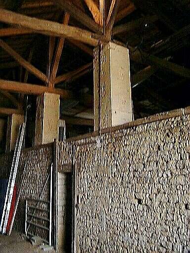 Dépendances, grange-étable-hangar, intérieur, mur de séparation, accès aux écuries et charpente soutenue par des piliers en maçonnerie.