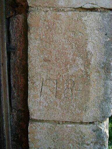 Elévation ouest, porte piétonne donnant accès à la cour du logis, encadrement de droite, détail d'une pierre sur laquelle est gravée la date 1789.