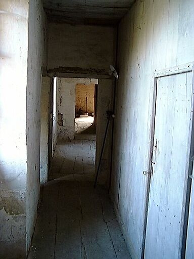 Logis, étage, couloir pratiqué du côté est par les cloisons en bois des chambres, vue vers le grenier.