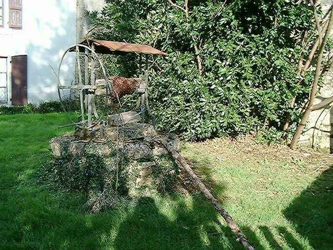 Puits à roue dans la cour devant le logis.