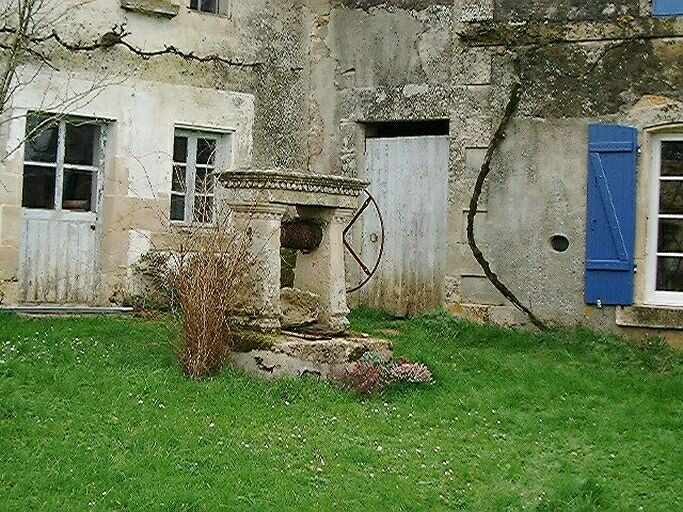 Puits avec roue crantée dans la cour.