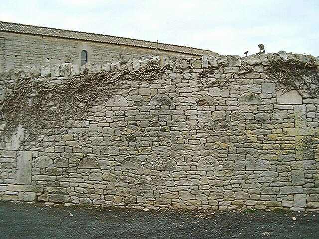 Mur de clôture sud, détail de la mise en oeuvre avec remplois de fragments de couvercles de sarcophages.