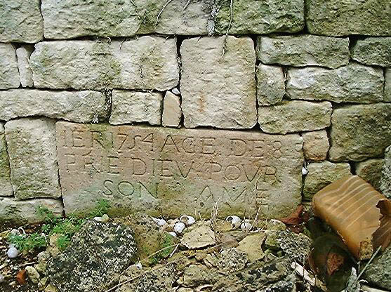 Mur de clôture est, détail du fragment de pierre tombale daté 1754 remployé.