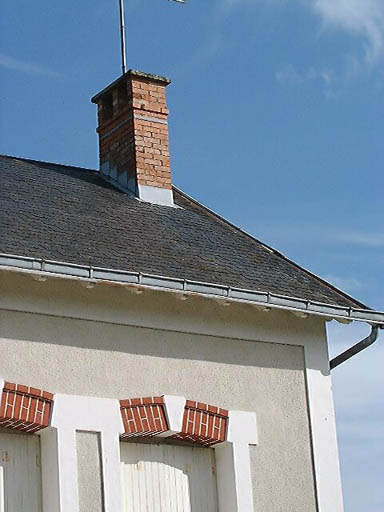 Logis, détail d'un linteau de baie et d'une souche de cheminée en briques.