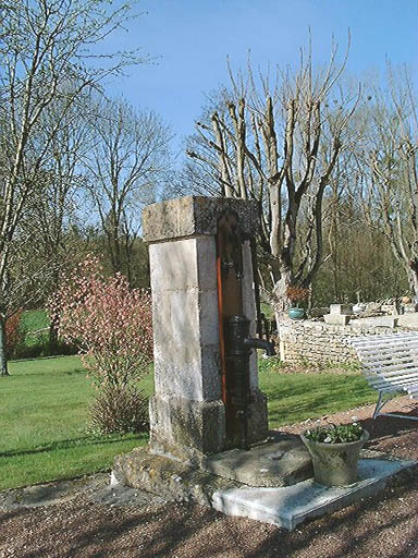 Pile maçonnée supportant une pompe en fonte.