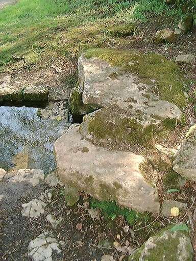 Détail de la pierre monolithe couvrant la source maçonnée.