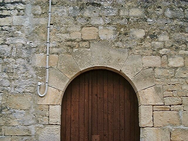 Eglise, élévation antérieure, porte d'entrée, détail de l'appareil de l'arc en plein cintre.