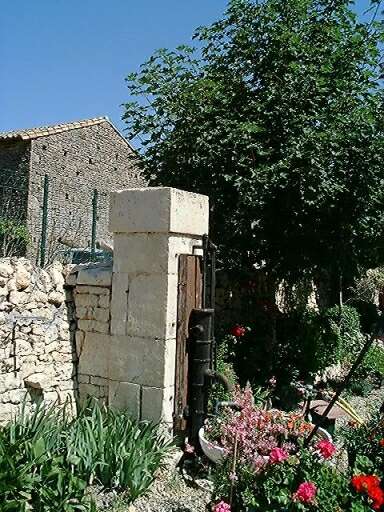 Pilier maçonné avec pompe en fonte, à gauche de la cour, vue d'ensemble.