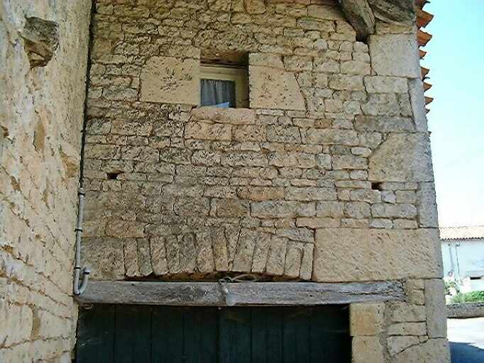 Corps de bâtiment adossé au logis, détail du linteau de la porte et de son arc de décharge.