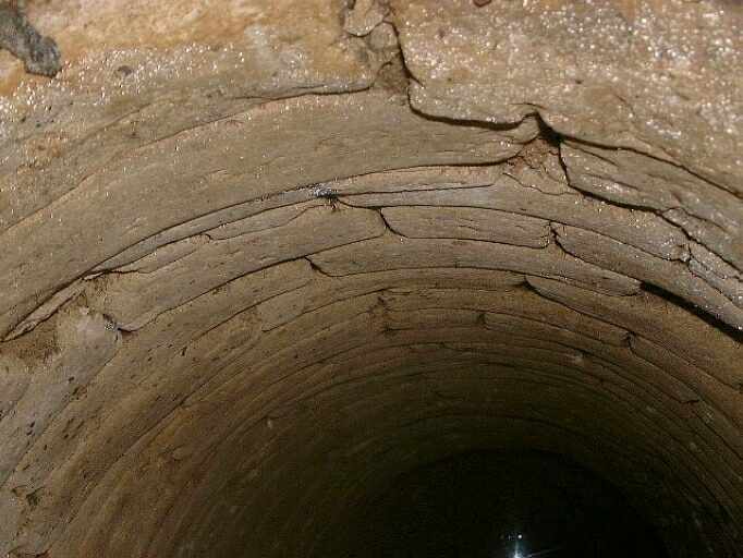 Puits au ras du sol (la margelle a disparu), situé dans une petite dépendance au sud du logis, détail de la maçonnerie.