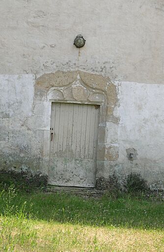 La porte à accolade et blason sur élévation antérieure.