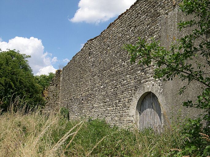 L'élévation postérieure de la grange, avec la porte en plein cintre et, à l'arrière plan, ce qu'il reste d'une tour.