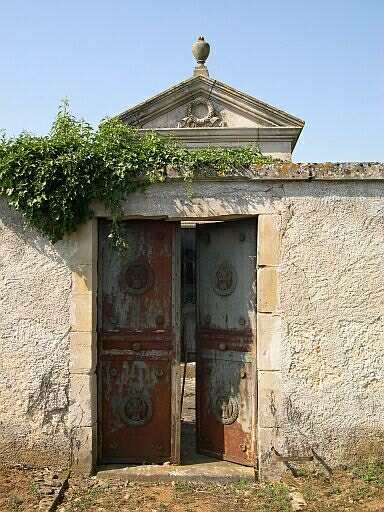 Le second enclos entourant la chapelle avec la porte métallique décorée de couronnes et de sabliers ailés
