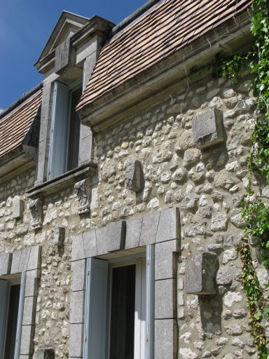 Pierres de taille dépassant de la façade du logis.