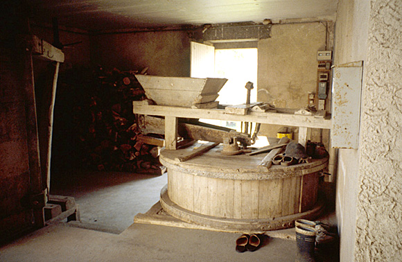 Moulin à chaux : trémie en bois et goulotte d'alimentation des meules.