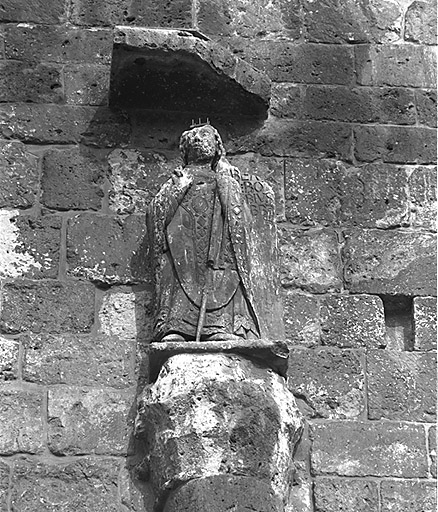 Statue de l'abbé Roger surmontant la demi-colonne placée à droite du portail.