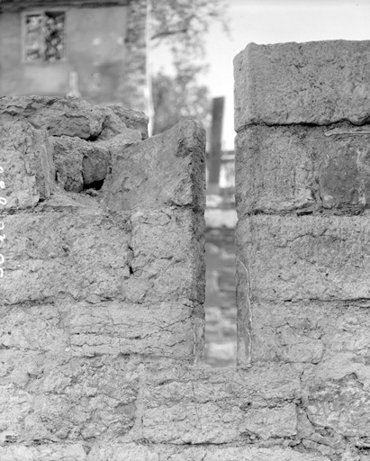 Mur nord des bâtiments conventuels attenants à la galerie nord du cloître, détail : baie en meurtrière avec vestige d'enduit : état en1990