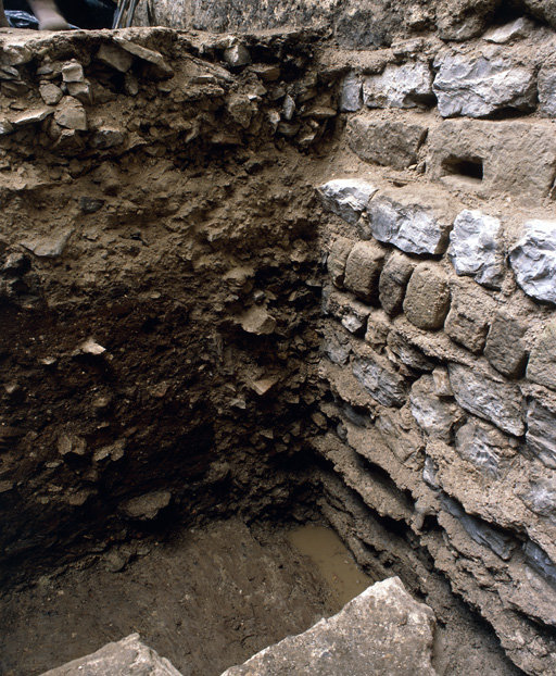 Portail nord, fouilles de mars 1991 : maçonneries de fondation et coupe stratigraphique sur la tranchée de fondation.