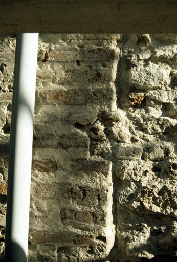 Elévation est sur la rue : piédroit d'une fenêtre géminée avec reprise à la peinture, en rouge et blanc, des briques et des joints.