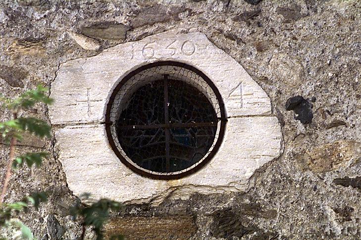 Oculus sur le bas-côté nord, daté 1650.