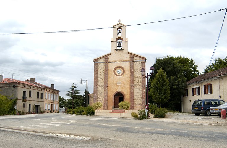 Vue de la façade occidentale de l'église et de la place de l'église.