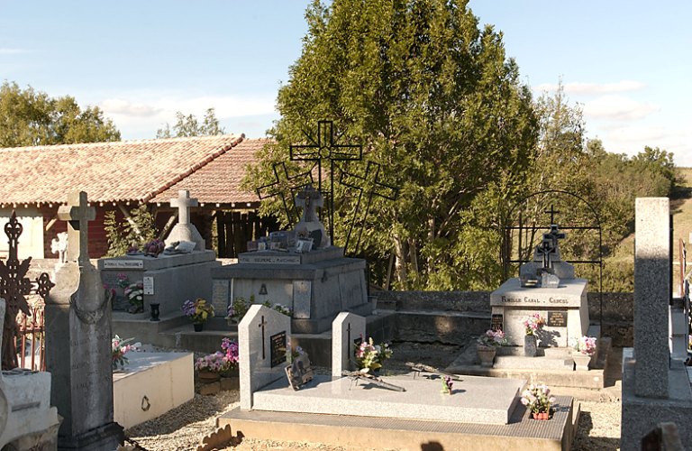 Vue, au fond du cimetière, de la tombe en marbre surmonté des trois croix du Clavaire en fer forgé, milieu 20e siècle.