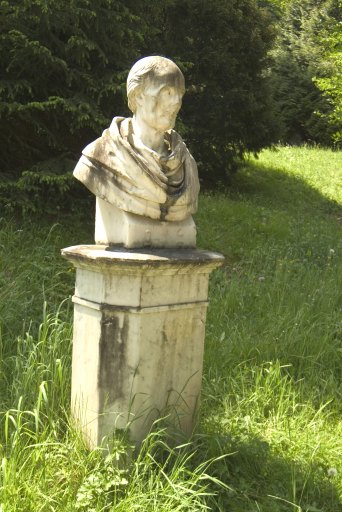 Buste de style néoclassique, en marbre blanc de Saint-Béat, ponctuant le détour d'une allée dans le parc.