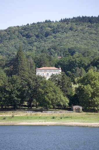 Vue d'ensemble de la maison dans son cadre végétal.