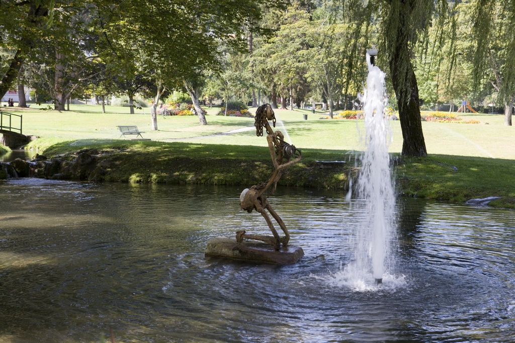 Statuaire contemporaine et jet d'eau dans la pièce d'eau.