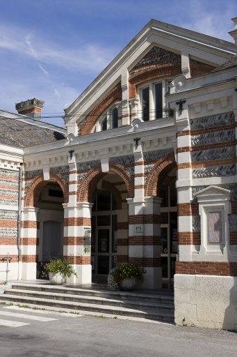 Façade sur rue : entrée monumentale sous fronton, orientée vers le parc.